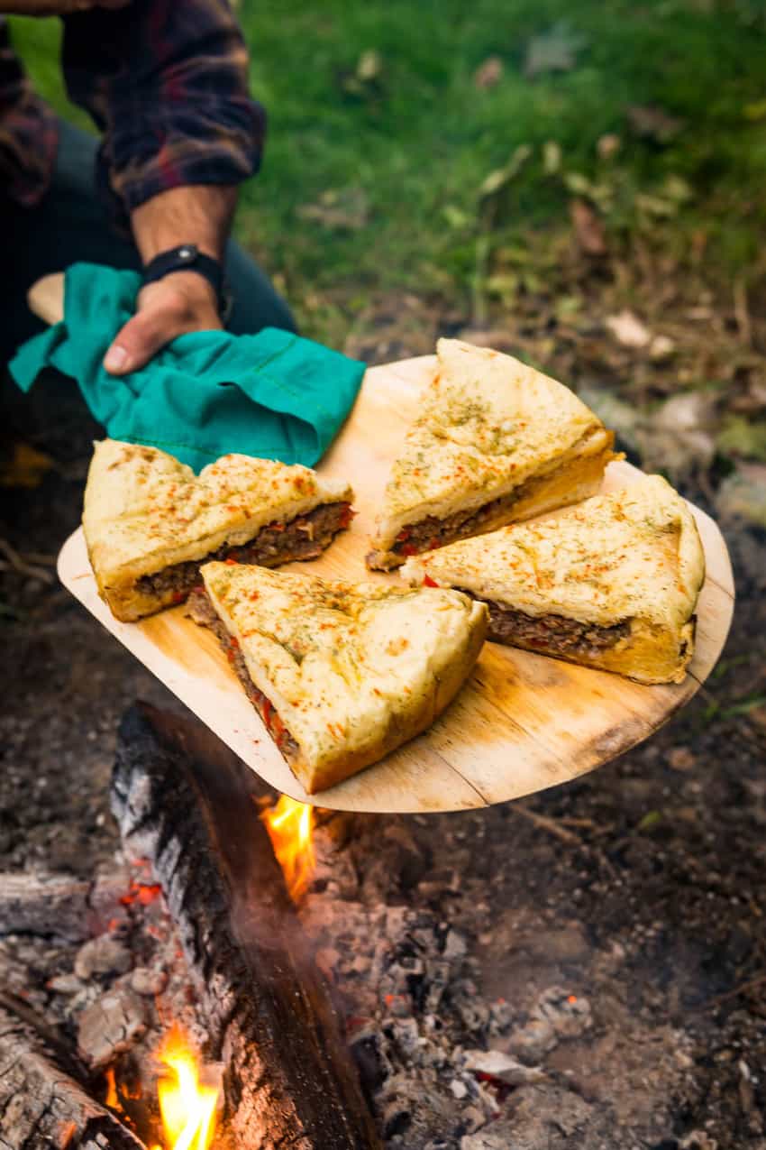 A woman in a hat is preparing food in an rv.